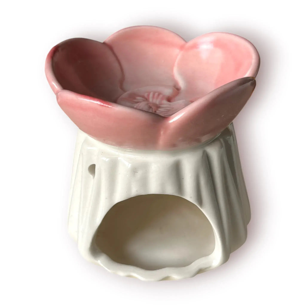 Difusor aromático de cerámica esmaltada con base plisada blanca y cuenco superior en forma de flor color rosado pastel.