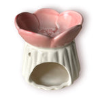 Difusor aromático de cerámica esmaltada con base plisada blanca y cuenco superior en forma de flor color rosado pastel.