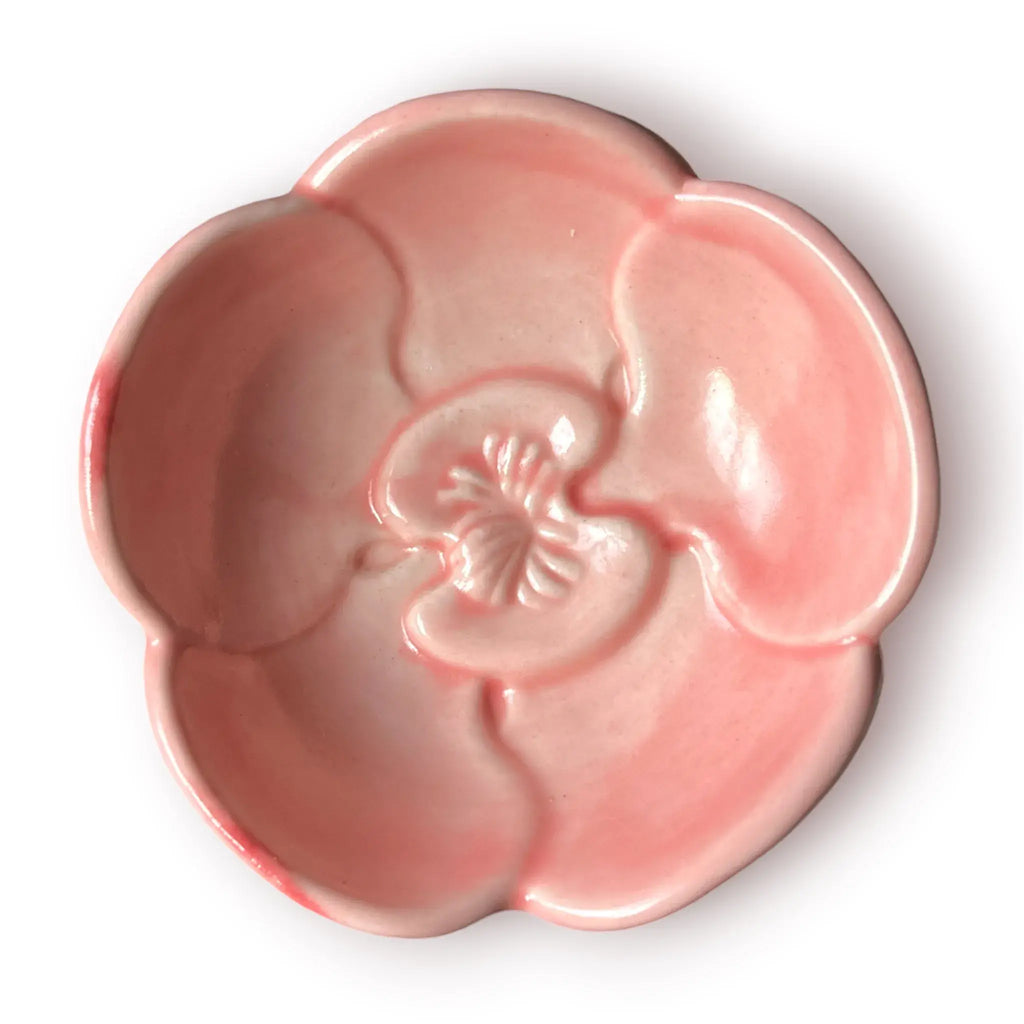 Difusor aromático de cerámica esmaltada con base plisada blanca y cuenco superior en forma de flor color rosado pastel.