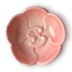 Difusor aromático de cerámica esmaltada con base plisada blanca y cuenco superior en forma de flor color rosado pastel.