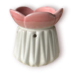Difusor aromático de cerámica esmaltada con base plisada blanca y cuenco superior en forma de flor color rosado pastel.