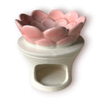 Difusor aromático de cerámica esmaltada con base blanca texturizada con relieve de libélula y cuenco superior rosado en forma de flor.