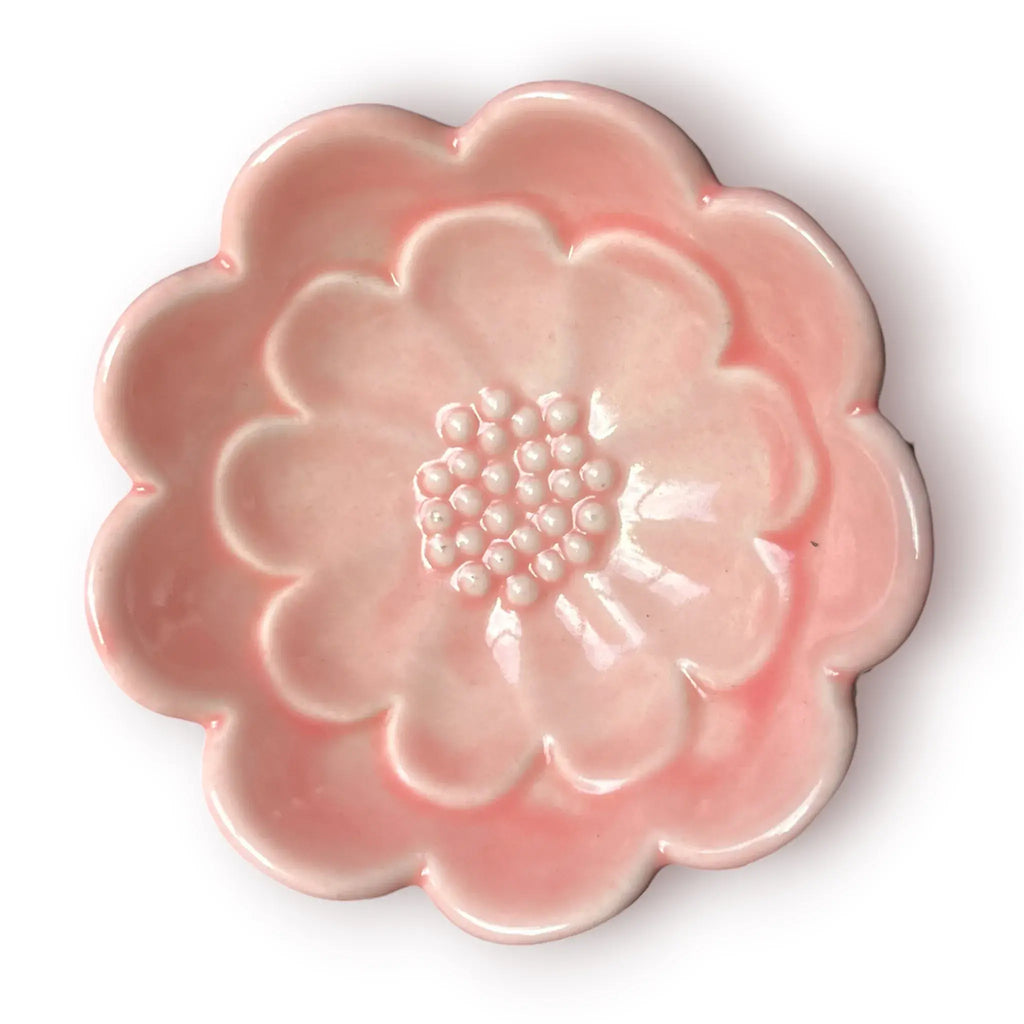 Difusor aromático de cerámica esmaltada con base blanca texturizada con relieve de libélula y cuenco superior rosado en forma de flor.