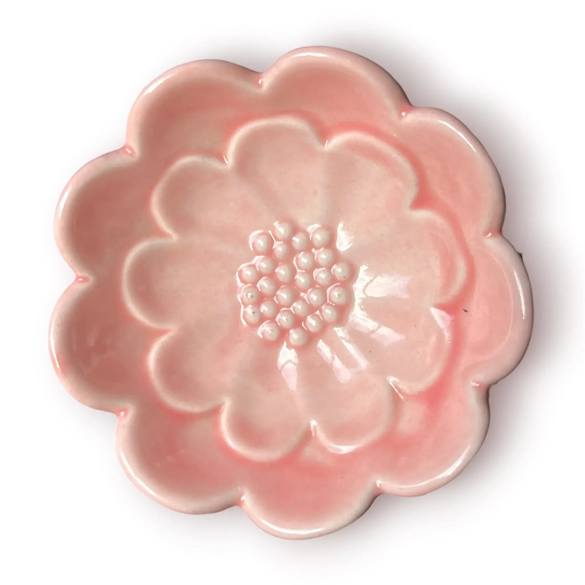 Difusor aromático de cerámica esmaltada con base blanca texturizada con relieve de libélula y cuenco superior rosado en forma de flor.